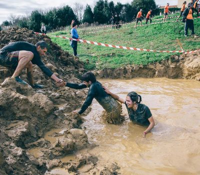 bigstock-Team-helping-to-cross-mud-pit--116872709